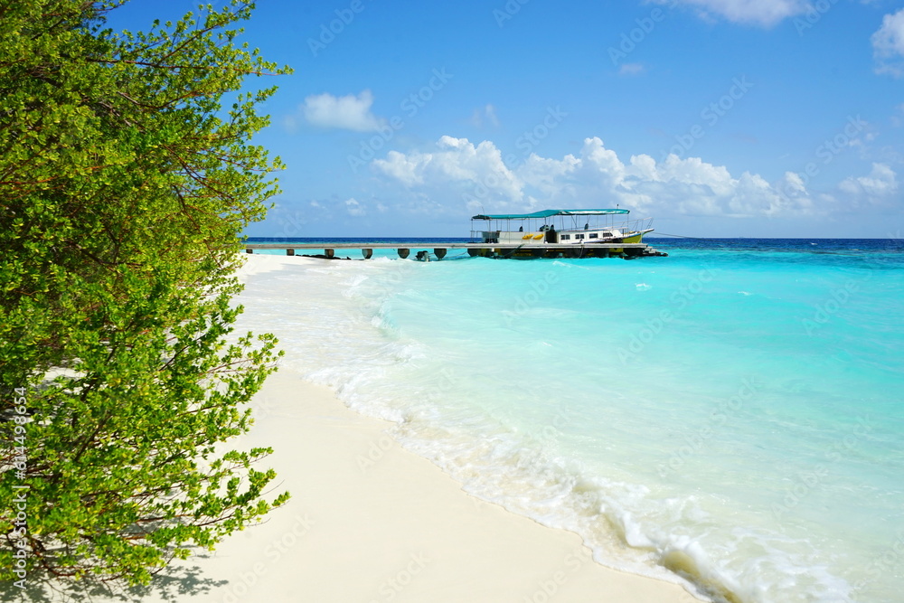Paradise island in the Maldives. Tropical summer beach with yellow boat on background turquoise ocean. Luxury travel for relaxation. White sand sea beach. Summer vacation and travel concept. Paradise island in the Maldives. Tropical summer beach with yellow boat on background turquoise ocean. Luxury travel for relaxation. White sand sea beach. Summer vacation and travel concept.