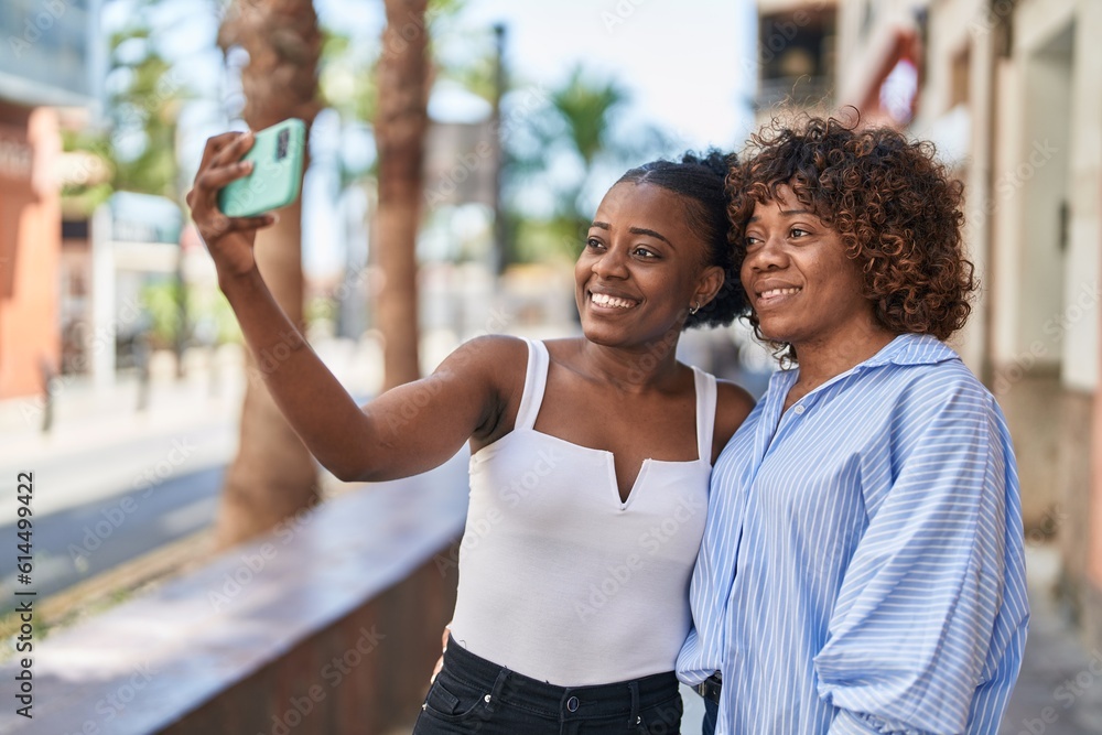 Naklejka premium African american women mother and daughter make selfie by smartphone at street
