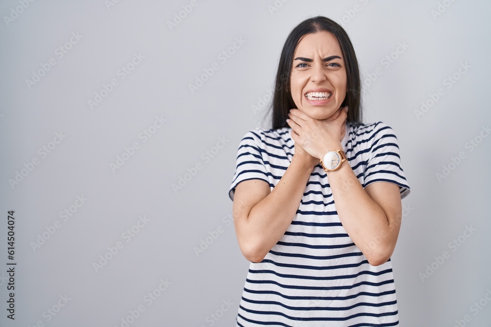 Young brunette woman wearing striped t shirt shouting suffocate because painful strangle. health problem. asphyxiate and suicide concept. Young brunette woman wearing striped t shirt shouting suffocate because painful strangle. health problem. asphyxiate and suicide concept.