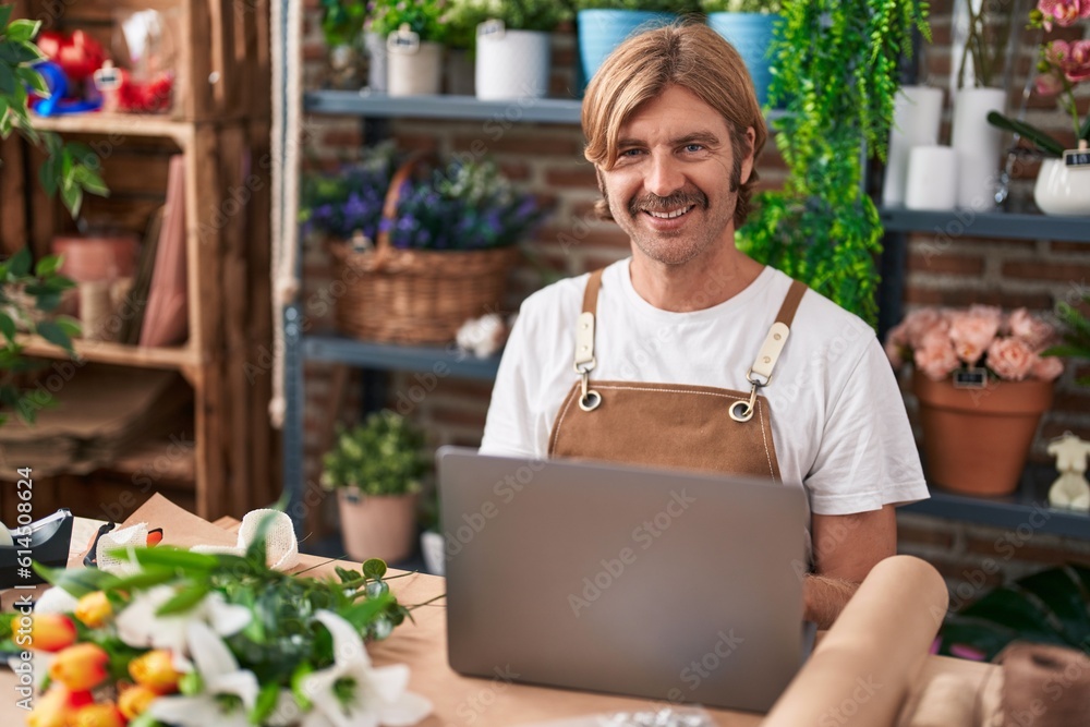 Young blond man florist smiling confident using laptop at flower shop Young blond man florist smiling confident using laptop at flower shop