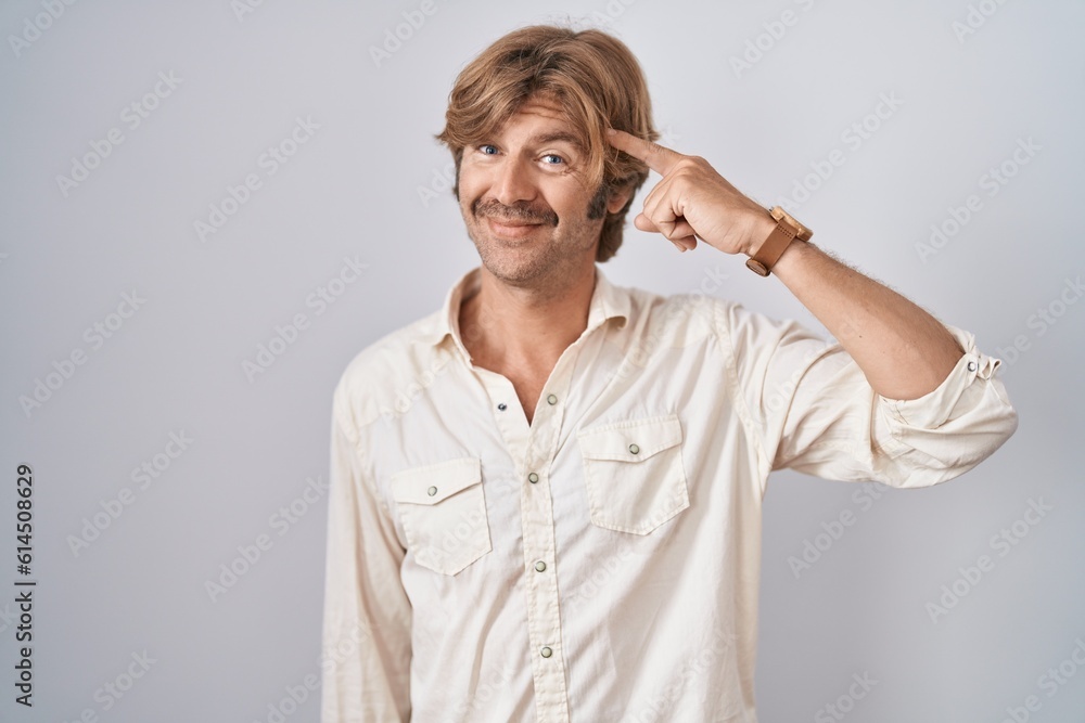 Middle age man standing over isolated background smiling pointing to head with one finger, great idea or thought, good memory Middle age man standing over isolated background smiling pointing to head with one finger, great idea or thought, good memory