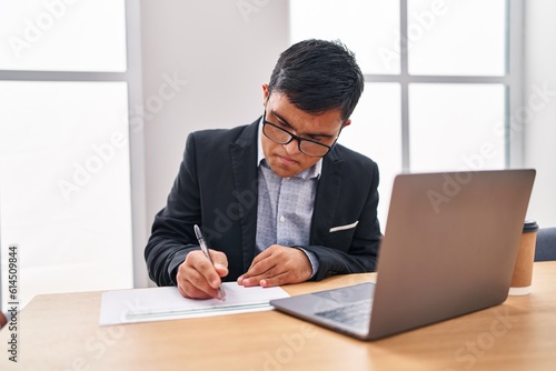 Down syndrome man business worker writing on document at office