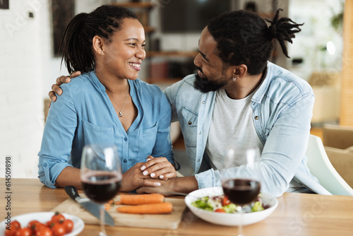 Happy African American couple talking while enjoying in lunch time at dining table.