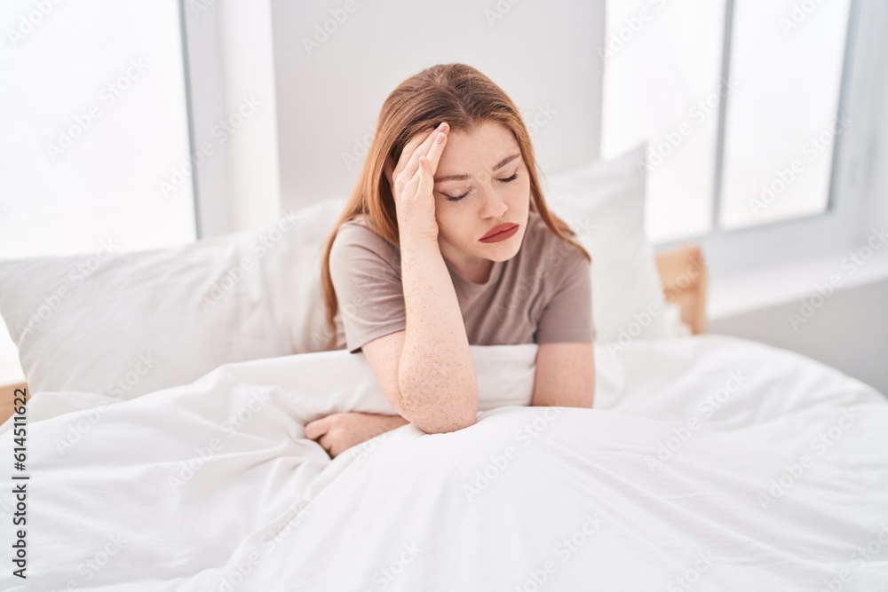 Young redhead woman stressed sitting on bed at bedroom Young redhead woman stressed sitting on bed at bedroom