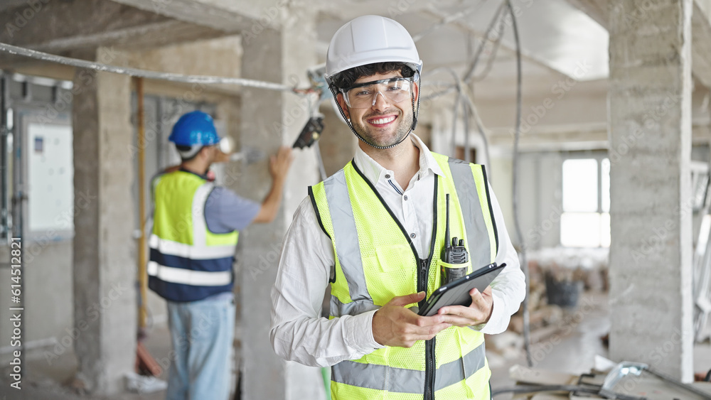 Two men builders smiling confident using touchpad at construction site Two men builders smiling confident using touchpad at construction site