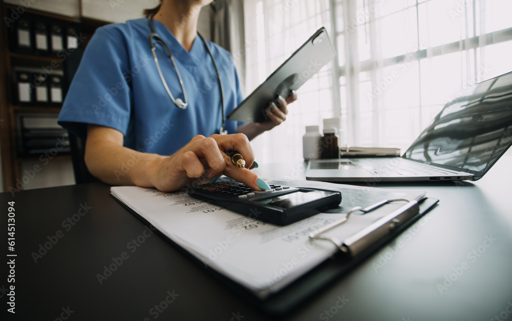 Fototapeta premium Young doctor with diary sitting at desk in medical clinic