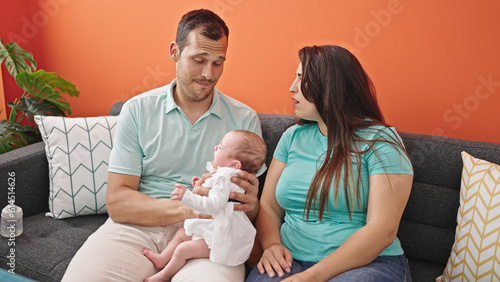 Family of three bonding sitting on the sofa at home photo