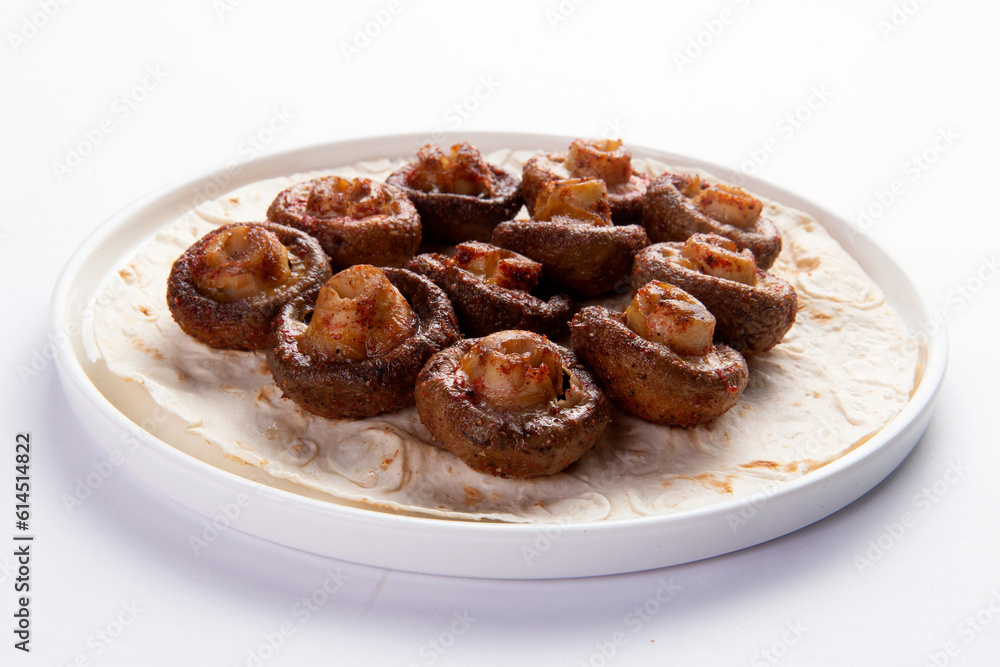 Grilled champignon mushrooms. On a white background. Grilled champignon mushrooms. On a white background.
