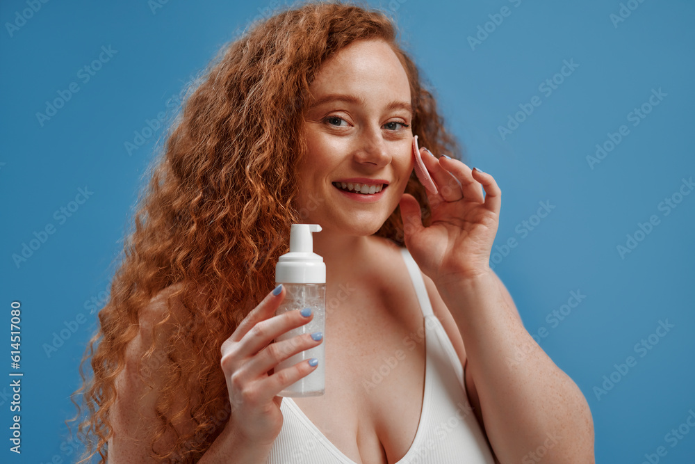 Redhead girl with freckles on a blue background Redhead girl with freckles on a blue background