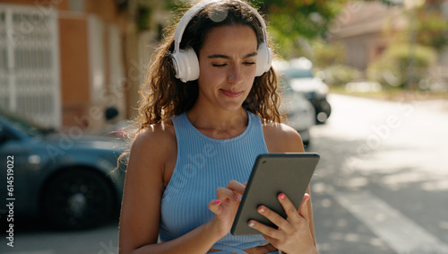 Free Download Young beautiful hispanic woman watching video on touchpad at street - GFXLoad