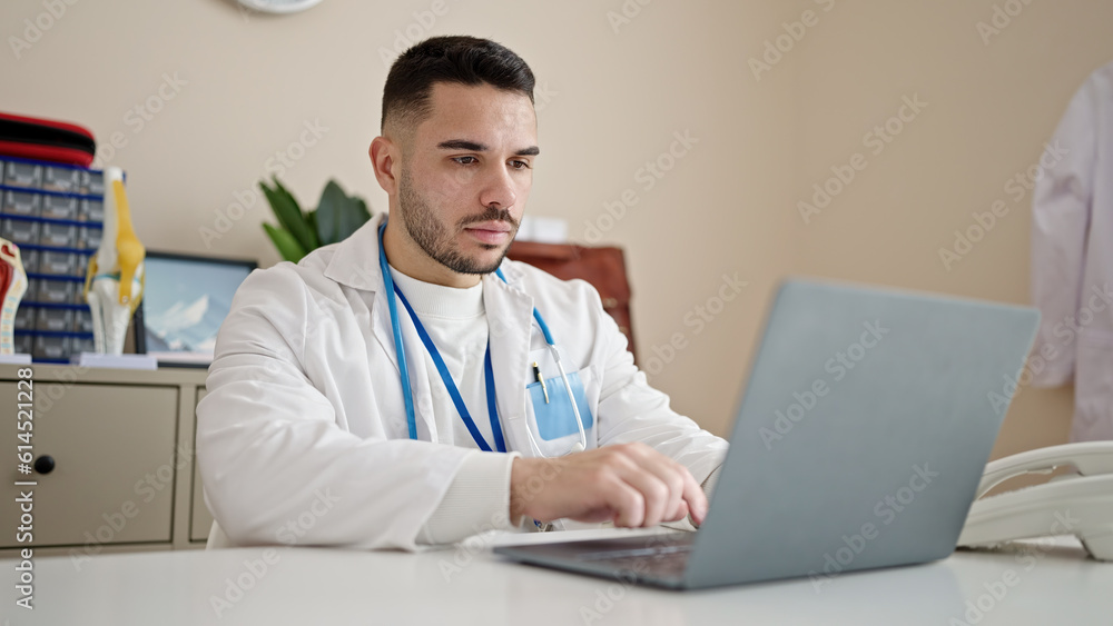Young hispanic man doctor using laptop working at clinic Young hispanic man doctor using laptop working at clinic