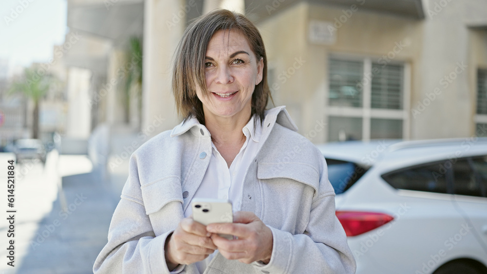 Middle age hispanic woman using smartphone at street Middle age hispanic woman using smartphone at street