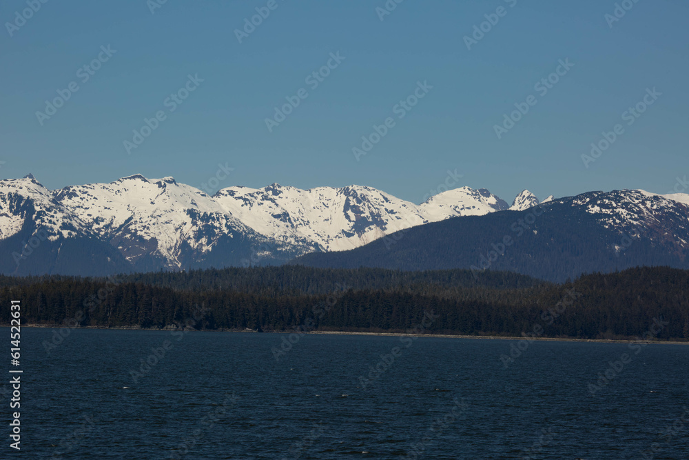 scenic landscape photograph of the snowcapped mountains of Alaska from the ocean view.