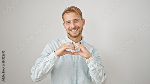 Young caucasian man smiling confident doing heart gesture with hands over isolated white background
