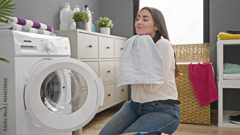 Young beautiful hispanic woman smiling confident smelling clean clothes at laundry room Young beautiful hispanic woman smiling confident smelling clean clothes at laundry room