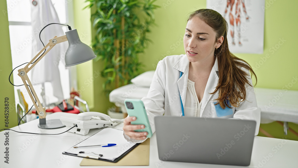 Young beautiful hispanic woman doctor using smartphone having online consultation at clinic Young beautiful hispanic woman doctor using smartphone having online consultation at clinic