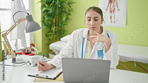 Wallpaper Mural Young beautiful hispanic woman doctor having online consultation writing on document at clinic Torontodigital.ca