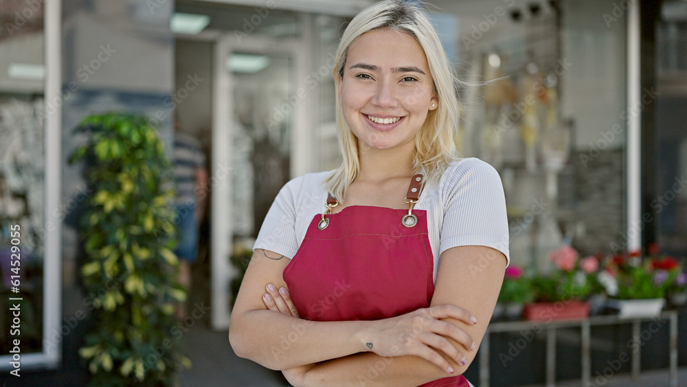 Young beautiful hispanic woman wearing apron standing with arms crossed gesture at flower shop Young beautiful hispanic woman wearing apron standing with arms crossed gesture at flower shop