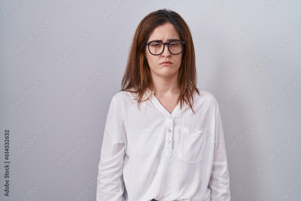 Brunette woman standing over white isolated background skeptic and nervous, frowning upset because of problem. negative person. Brunette woman standing over white isolated background skeptic and nervous, frowning upset because of problem. negative person.