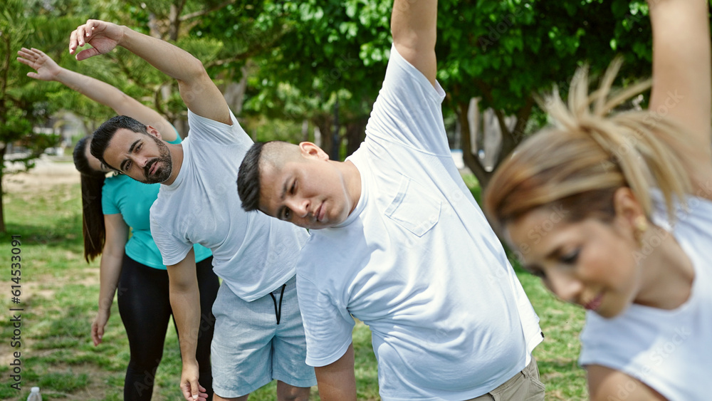 Fototapeta premium Group of people training yoga at park