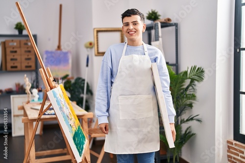 Non binary person at art studio looking positive and happy standing and smiling with a confident smile showing teeth