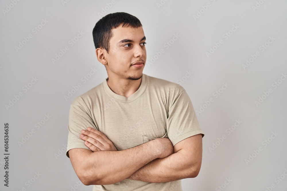 Young arab man wearing casual t shirt looking to the side with arms crossed convinced and confident Young arab man wearing casual t shirt looking to the side with arms crossed convinced and confident