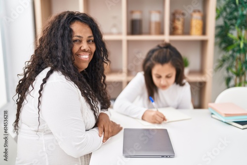 Mother and daughter smiling confident studying and working at home
