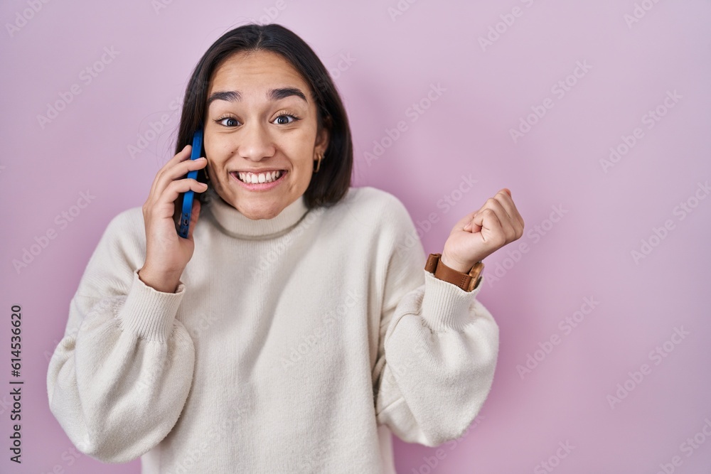 Young south asian woman having conversation talking on the smartphone screaming proud, celebrating victory and success very excited with raised arm Young south asian woman having conversation talking on the smartphone screaming proud, celebrating victory and success very excited with raised arm