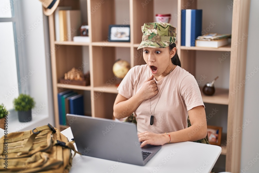 Young south asian woman wearing camouflage army uniform doing video call scared and amazed with open mouth for surprise, disbelief face Young south asian woman wearing camouflage army uniform doing video call scared and amazed with open mouth for surprise, disbelief face