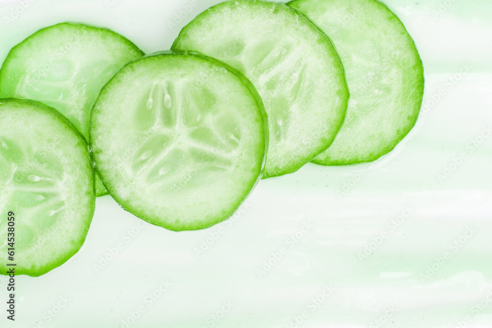 Slides of fresh cucumber on a cream smear. On a white background. Slides of fresh cucumber on a cream smear. On a white background.