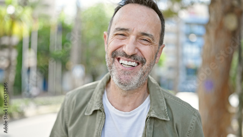 Middle age man smiling confident standing at park
