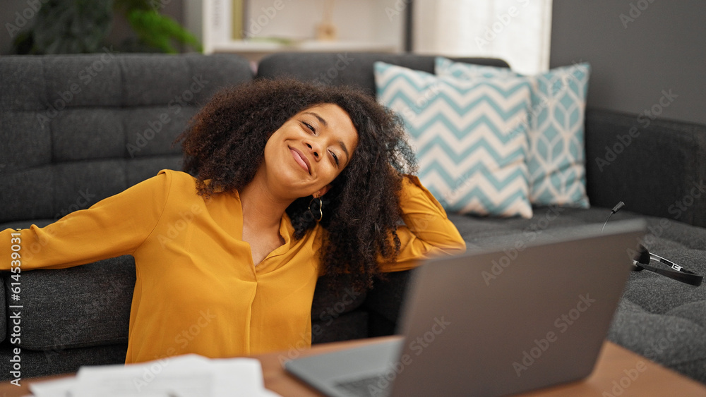 African american woman using laptop sitting on floor at home African american woman using laptop sitting on floor at home