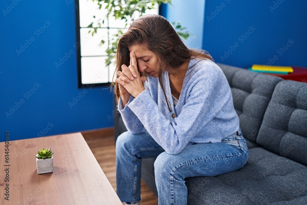 Young woman depressed sitting on sofa at home Young woman depressed sitting on sofa at home