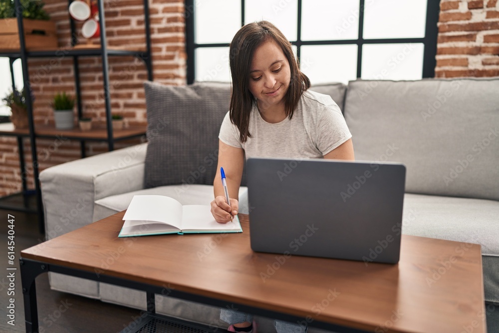 Down syndrome woman smiling confident working sitting on sofa at home Down syndrome woman smiling confident working sitting on sofa at home