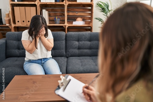 Quadro em tela Hispanic girl with down syndrome doing therapy with sad expression covering face with hands while crying