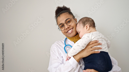 Mother and son doctor holding baby on arms over isolated white background