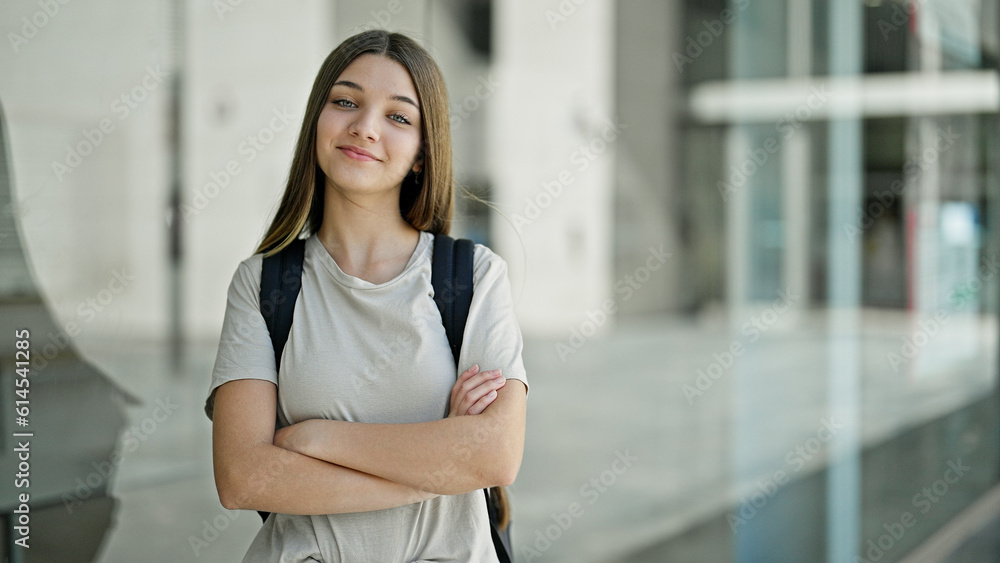 Young beautiful girl student wearing backpack standing with arms crossed gesture smiling at school Young beautiful girl student wearing backpack standing with arms crossed gesture smiling at school