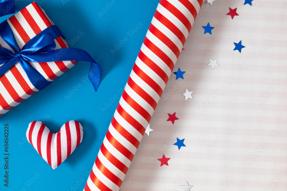 Obraz premium 4th of July, USA Presidents Day, Independence Day. Flat lay top view of patriotic wrapping paper and gift box twinkling confetti on blue background with space, promotion or greeting message, banner