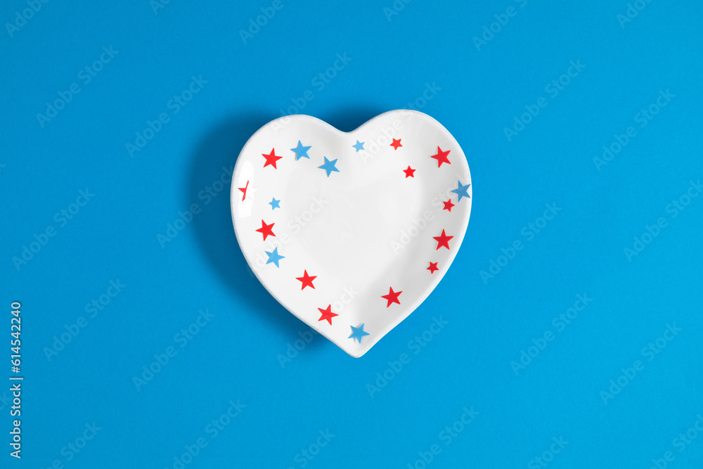 4th of July, USA Presidents Day, Independence Day, US election concept. Flat lay top view of heart shaped plate, star confetti on blue background with space for text or promotion and greeting message,