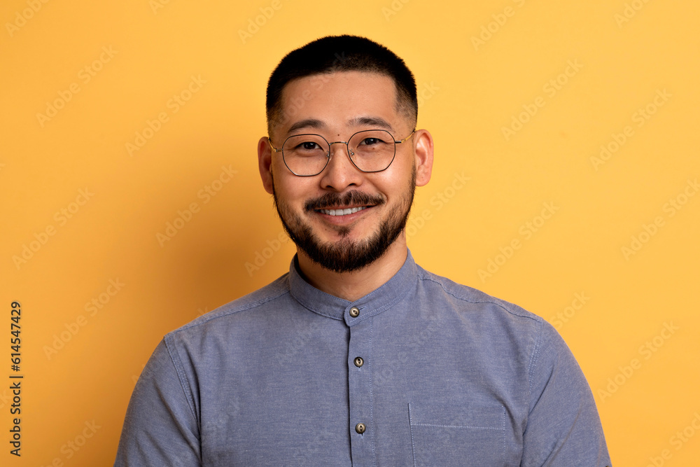 Obraz premium Portrait Of Handsome Young Asian Man In Eyeglasses Posing Over Yellow Background