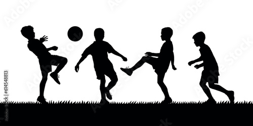 Boys playing soccer on grass field black silhouettes.