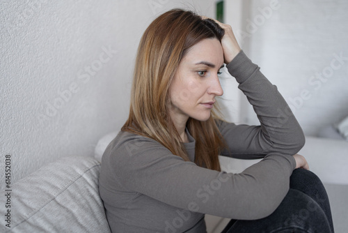 Stressed girl confused with unhappy problems, arguing with boyfriend, cry and worry about unexpected pregnancy. Depressed young woman suffering from headache, migraine, feeling stressed, sick, tired. © Julija