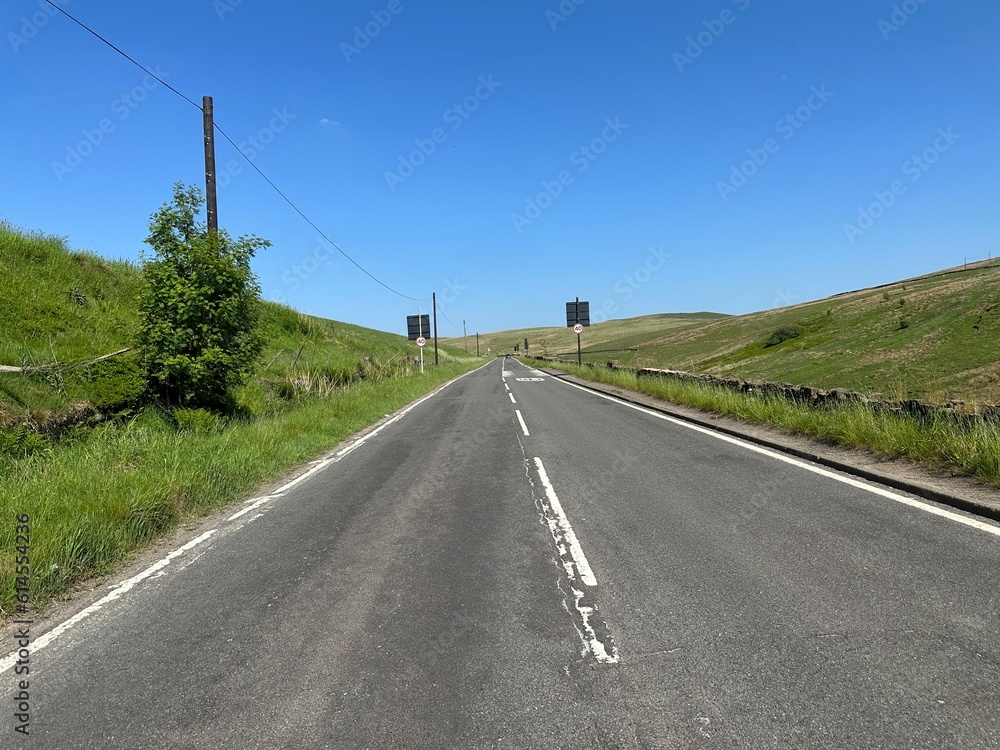 Looking along the, Huddersfield Road, with moorland, and a blue sky in, Denshaw, Oldham, UK