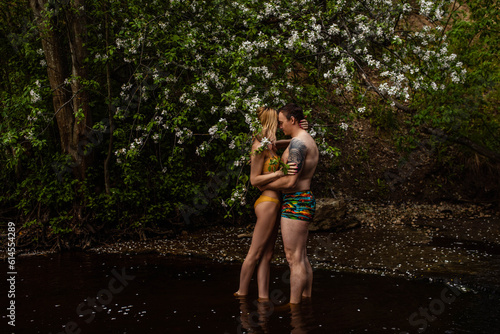 Beautiful couple in water hugging and kissing at night