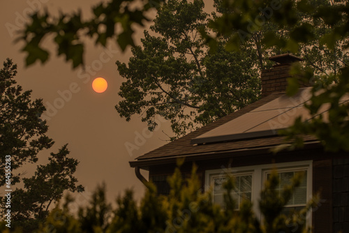 An orange sun in the middle  of the day  on  June,  7 in Long Island, New York,  the worst air quality in history due to smoke of forest fire in Canada