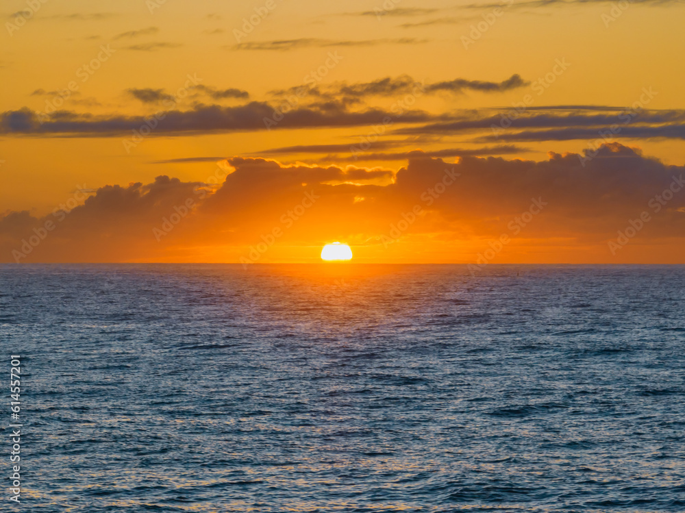Sun rising on the horizon over the ocean