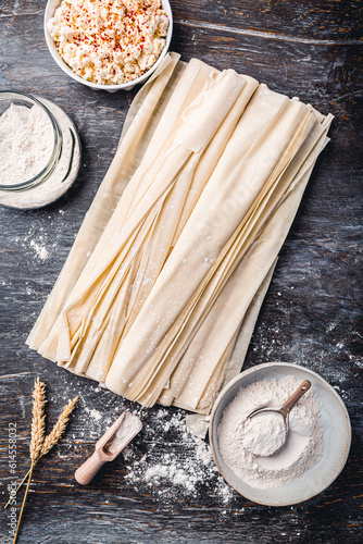 Baking preparation of savory pie with phyllo dough sheets stuffed with feta cheese photo