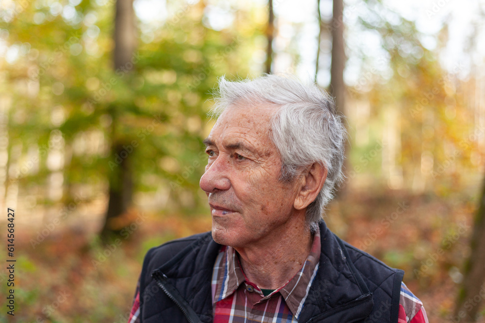 Portrait of an elderly man in the autumn forest. Selective focus. Portrait of an elderly man in the autumn forest. Selective focus.