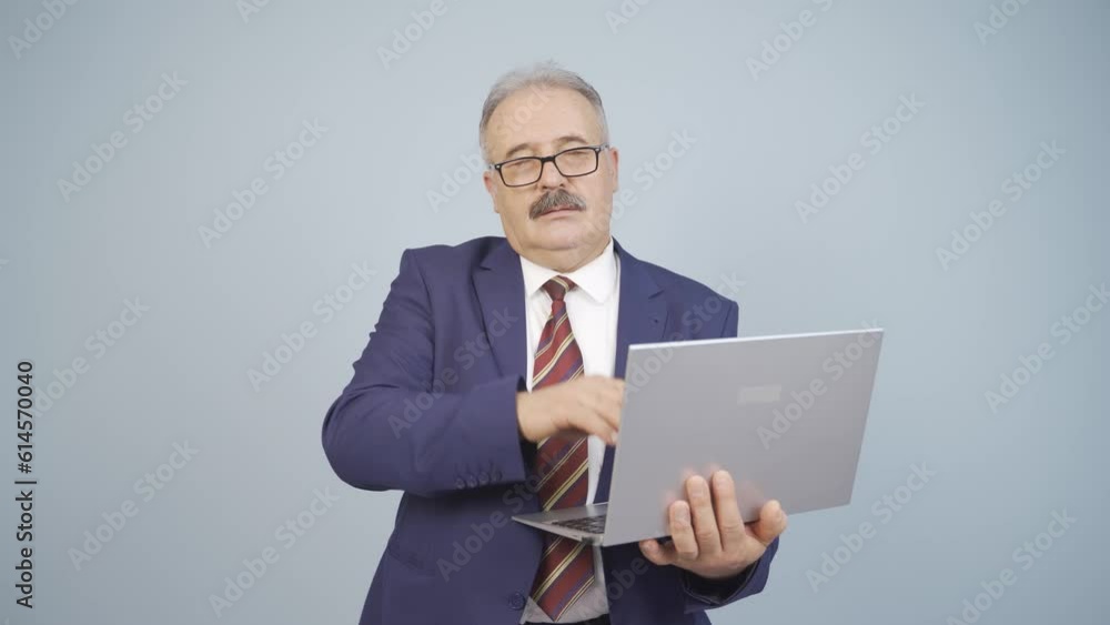 Businessman looking at laptop with tired expression. Businessman looking at laptop with tired expression.