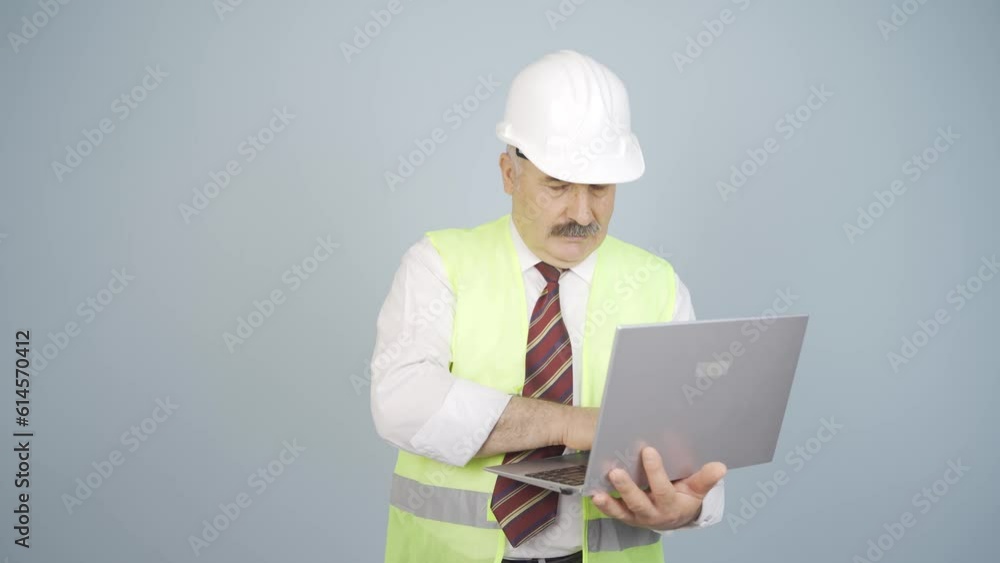 Engineer holding laptop laughing at camera. Engineer holding laptop laughing at camera.